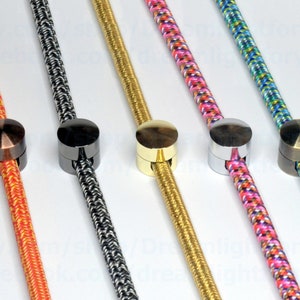 May include: Five different colored cords with metal cord end caps. The cords are orange, black and white, gold, pink and white, and blue, white, and green. The end caps are copper, black, gold, silver, and bronze.