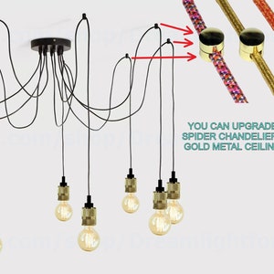 Puede incluir: Una ara&ntilde;a de ara&ntilde;a negra con 8 portal&aacute;mparas de oro y cables negros que cuelgan de un soporte de techo. La imagen muestra un primer plano de los clips de techo de metal dorado que se pueden utilizar para mejorar la ara&ntilde;a. El texto "YOU CAN UPGRADE YOUR SPIDER CHANDELIER WITH A GOLD METAL CEILING CLIPS" es visible en la imagen.