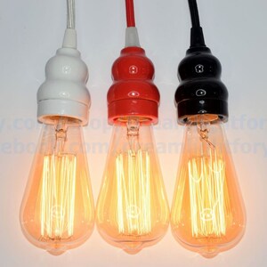 May include: Three pendant light fixtures with clear glass bulbs and ceramic lamp holders in white, red, and black.