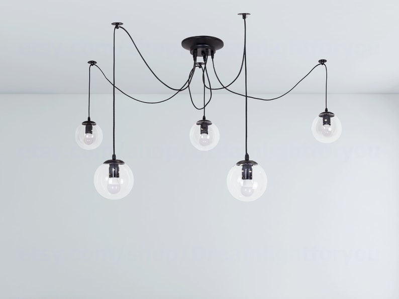 May include: A black ceiling light fixture with five clear glass globe shades hanging from black cords.