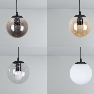 May include: Four pendant lights with different glass shades. The shades are clear, frosted, amber, and brown.