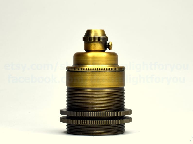 May include: A brass light bulb socket with a threaded base and a small screw on the top. The socket is designed for use with standard light bulbs.