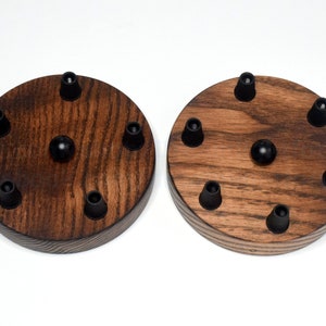 May include: Two round wooden ceiling light fixture bases with six black wire connectors each. The bases are made of dark stained wood with a natural wood grain pattern.