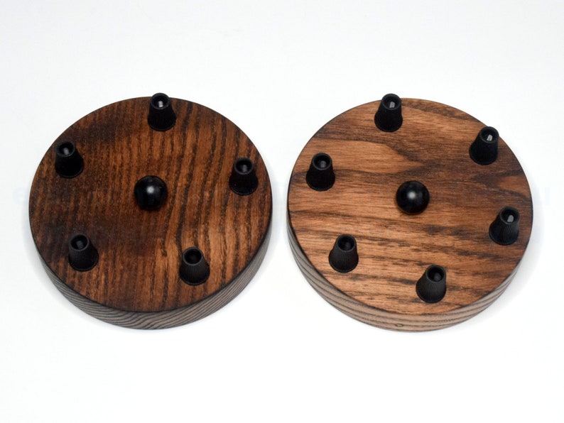 May include: Two round wooden ceiling light fixture bases with six black wire connectors each. The bases are made of dark stained wood with a natural wood grain pattern.
