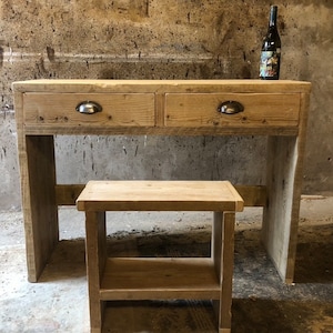 May include: A rustic wooden console table with two drawers and a small wooden stool. The table has a natural wood finish and metal drawer pulls. The stool is also made of wood and has a simple design.