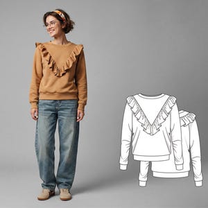 May include: A tan-colored sweatshirt with a ruffled neckline and long sleeves. The model is wearing blue jeans and tan sneakers. A line drawing of the sweatshirt is also shown. The sweatshirt is a casual, everyday garment.
