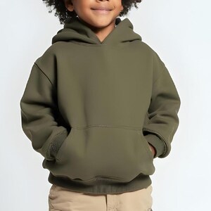 May include: An olive green hooded sweatshirt with a kangaroo pocket. The sweatshirt is made of a soft material and has ribbed cuffs and hem. The child is wearing khaki pants.