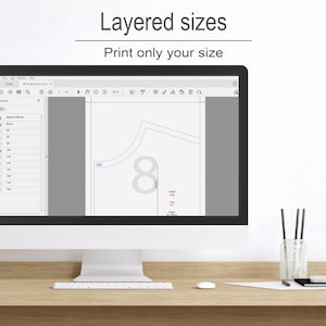 May include: A computer monitor displays a digital sewing pattern with layered sizes. The screen shows a pattern piece with the number 8 and size 104. The text "Layered sizes" and "Print only your size" are at the top of the screen.