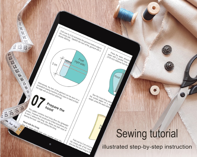 a sewing tutorial on a tablet, with various sewing tools such as scissors, thread, and fabric visible on a wooden surface.