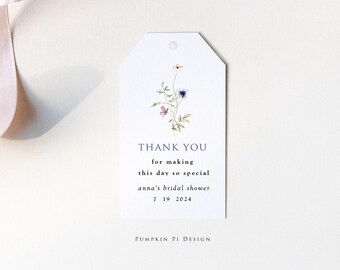 May include: A white thank you tag with a watercolor illustration of a bouquet of flowers. The text reads "THANK YOU for making this day so special anna's bridal shower 7 19 2024 PUMPKIN PI DESIGN".