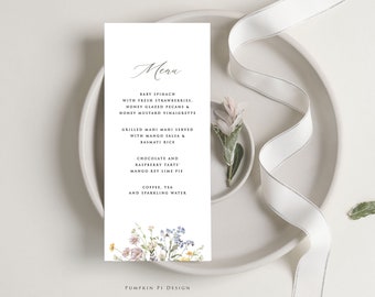 Puede incluir: Una tarjeta de menú blanca con un diseño floral en la parte inferior. El menú incluye una ensalada de espinacas baby con fresas frescas, nueces pecanas glaseadas con miel y vinagreta de miel y mostaza. También incluye mahi mahi a la parrilla servido con salsa de mango y arroz basmati, tartas de chocolate y frambuesa, pastel de lima y mango, café, té y agua con gas. La tarjeta también incluye el texto "Pumpkin Pi Design".