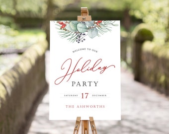 May include: A white welcome sign with a red and green watercolor floral design. The sign reads "Welcome to our Holiday Party, Saturday 17 December, The Ashworths".