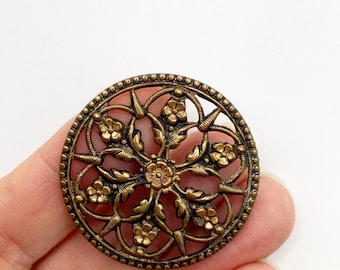 Antique Victorian pierced metal button in floral design.