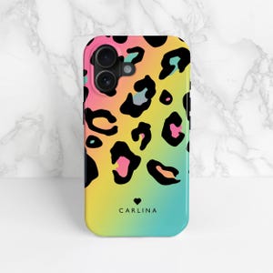Rainbow leopard print phone case with a personalised name and love heart, shown on an iPhone as an example and stood up against a marble background