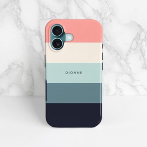 Pink cream and blue stripe print pattern phone case shown on an iPhone 16 as an example, stood up against a marble background