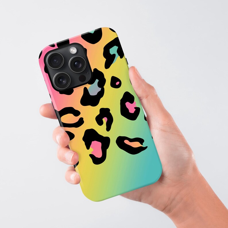 a hand holding a phone case with a colorful leopard print