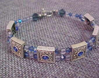 Pulsera vintage con cierres deslizantes plateados y detalles de diamantes de imitación azules. Engastada con medallones azules y blancos.