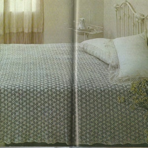 Peut inclure: Une couvre-lit blanche en crochet avec un motif floral délicat, drapé sur un cadre de lit en métal blanc avec une tête de lit blanche. Le lit est fait avec des oreillers blancs et une couverture blanche.