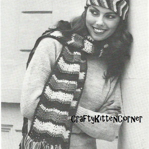 May include: A crocheted scarf and headband set in a chevron pattern of white, gray, and dark brown. The scarf has fringe at the ends. The headband and scarf are worn with a light-colored sweater. The text "CraftyKittenCorner" is visible.