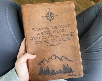 Może przedstawiać: Brązowy, skórzany dziennik z kompasem i tekstem "SHOW ME THE RIGHT path. O LORD. POINT OUT THE road FOR ME TO FOLLOW psalm 25:4" oraz górskim krajobrazem z drzewami. Dziennik jest podpisany "Mykhak Sumen".