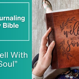 K&ouml;nnte beinhalten: Ein braunes, ledergebundenes Tagebuch mit dem Text "It is well with my soul" und dem Namen "Sarah Palgorski" auf der Titelseite. Das Tagebuch ist Teil der ESV Journaling Study Bible.