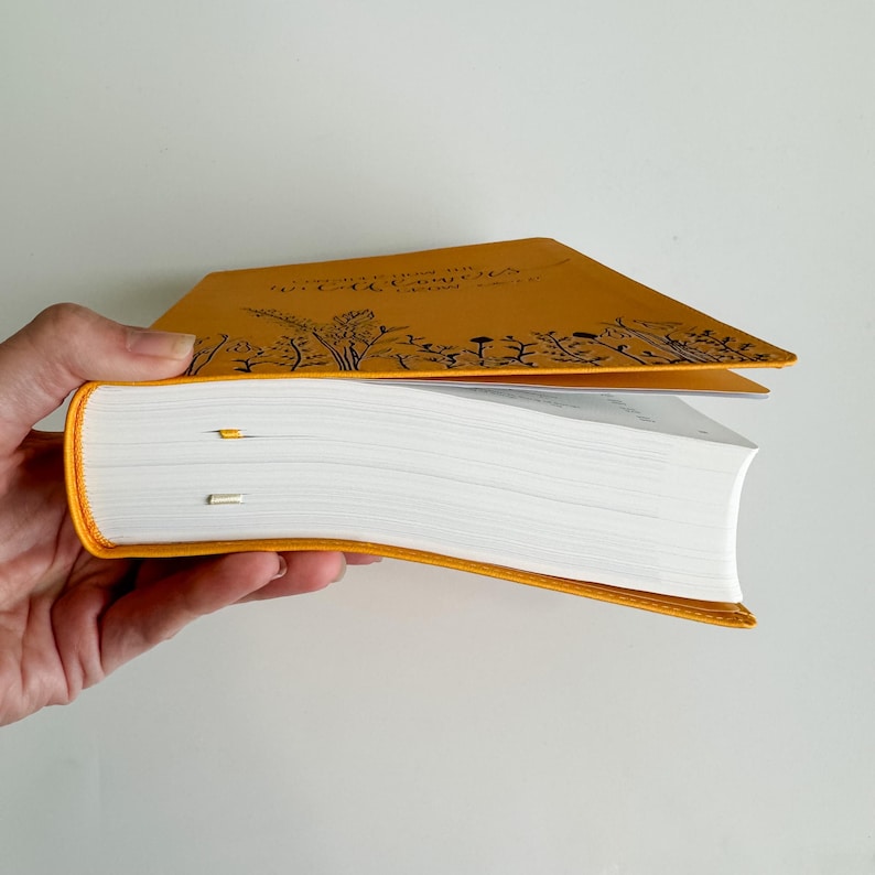 May include: A yellow hardcover book with the title "Grow Where You Are Planted" in black lettering. The book is open and the pages are white.