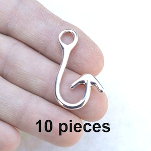 May include: Ten silver-toned metal fishing hook charms. The hooks are about 1 inch long and have a loop at the top for attaching to jewelry or other crafts.