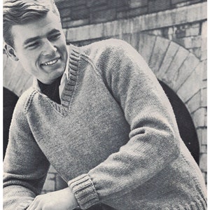 以下が含まれることがあります： Vネックと長袖のグレーのニットセーターを着た男性。セーターはリブ編みの襟と袖口です。