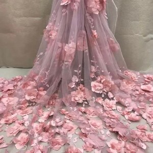 May include: Pink floral lace fabric with 3D flowers. The fabric is sheer and delicate, with a soft, feminine feel.