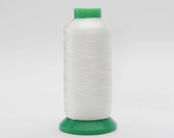 May include: A spool of white thread with a green plastic top and bottom.