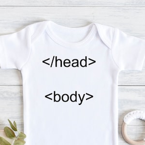 以下が含まれることがあります： 白いベビーロンパースに「</head>」と「<body>」の文字が印刷されています。