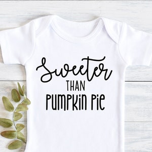 Peut inclure: Combinaison bébé blanche avec un texte noir qui dit "Sweeter than Pumpkin Pie".