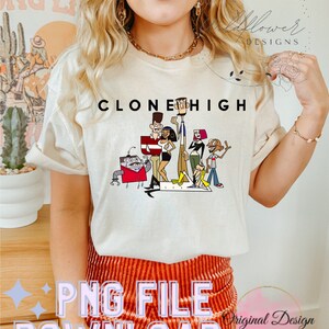 May include: A white t-shirt with the text "Clone High" printed on it. The design features cartoon characters from the show, including a robot, a girl with pink hair, and a boy with a red shirt.