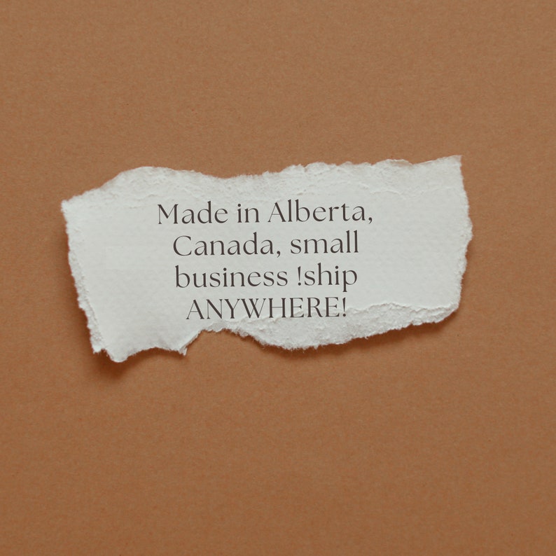 May include: A white piece of paper with torn edges on a brown background. The paper has the text "Made in Alberta, Canada, small business! ship ANYWHERE!" written on it.