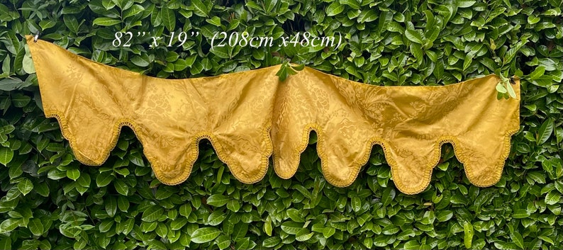 May include: Gold fabric valance with a scalloped edge. The valance measures 82 inches by 19 inches (208 cm x 48 cm).