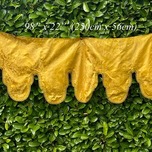 May include: A gold fabric valance with a scalloped edge and a repeating pattern. The valance measures 98 inches by 22 inches (250 cm x 56 cm).
