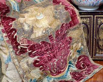 May include: A vintage embroidered fabric panel with a floral design. The panel features a large, gold-colored flower with a red velvet background. The fabric is worn and faded, giving it a unique antique look.
