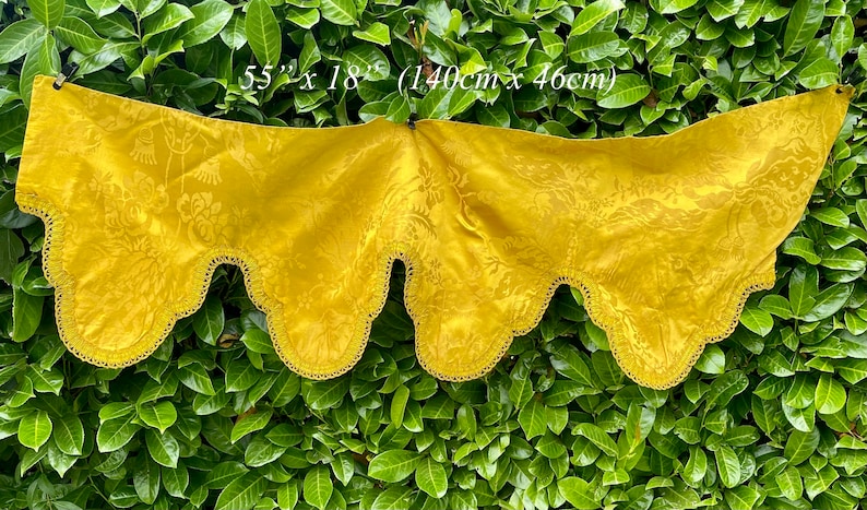 May include: A yellow fabric valance with a scalloped edge and a floral pattern. It measures 55 inches by 18 inches (140 cm x 46 cm).
