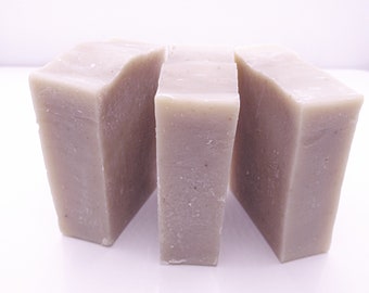 May include: Three bars of handmade soap, each a light gray color. The bars are rectangular and have a slightly rough texture.