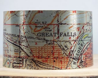 May include: A silver metal bracelet with a vintage map of Great Falls, Montana. The map features the Missouri River, the city's streets, and the text "GREAT FALLS".