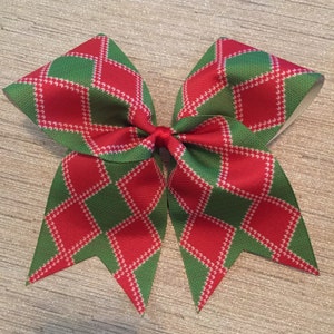 May include: A red and green plaid cheer bow with a white diamond pattern.