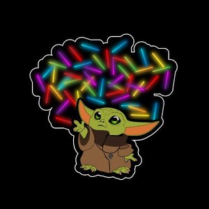 May include: A green alien character with large ears, wearing a brown robe, is surrounded by colorful glowing sticks. The character is looking up at the sticks.