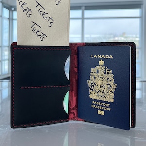 Cartera para pasaporte de cuero negro Heritage Can/USA con forro de filigrana roja invertida
