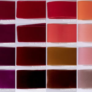 May include: A grid of sixteen velvet ribbons in various shades of red, pink, orange, and brown. Each ribbon is labeled with a color name and number, including Beauty 422, Scarlet 644, Rouge 629, Orange 445, Wine 424, Dark Red 614, Capucine 601, Coral 618, Bordeaux 390, Acajou 415, Copper 447, Dusty Rose 623, Fuchsia 709, Burgundy 434, Havanne 706, and Colonial Rose 263.