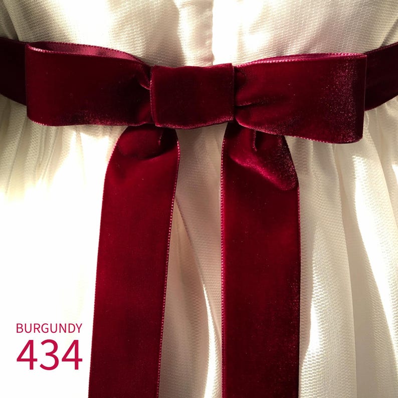 May include: A deep burgundy velvet ribbon tied into a bow, positioned horizontally across a white textured fabric. The text BURGUNDY 434 is printed in the lower left corner of the image in a matching dark red color.