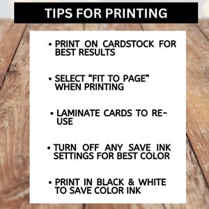May include: A white card with black text against a wooden backdrop. The card provides printing tips, such as using cardstock, selecting 'fit to page', laminating, and turning off save ink settings. The text is in a clear, readable font.