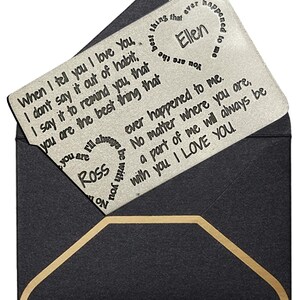 May include: A silver metal card with a message engraved on it. The message reads "When I tell you I love you, I don't say it out of habit. I say it to remind you that you are the best thing that ever happened to Ellen. No matter where you are, a part of me will always be with you. I love you." The card is in a black envelope with a gold trim.