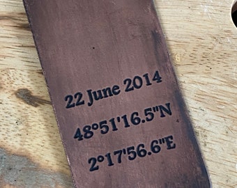 May include: A rectangular copper money clip with the date "22 June 2014" and coordinates "48°51'16.5"N 2°17'56.6"E" engraved on it. The clip has a slightly distressed appearance.