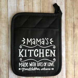 May include: Black quilted pot holder with white text that reads "Mama's Kitchen Made with lots of love - Grandchildren welcome -"