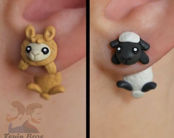 以下が含まれることがあります： タンカラーのラマと白黒の羊をモチーフにしたスタッドピアス。ラマのピアスは前面に頭と前足、背面に胴体がデザインされています。羊のピアスは前面に頭、背面に胴体がデザインされており、耳たぶを挟むような形状になっています。